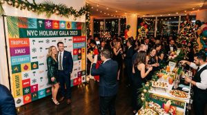 A festive NYC holiday party with a colorful custom step and repeat backdrop with guests taking photos